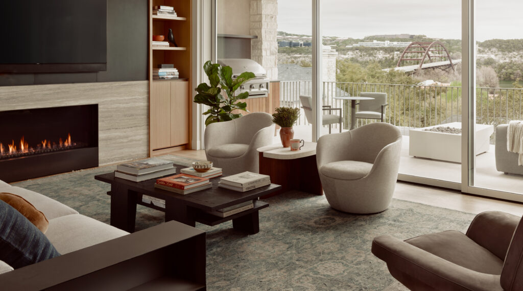 Modern living area with natural stone fireplace and views of the Pennybacker bridge.